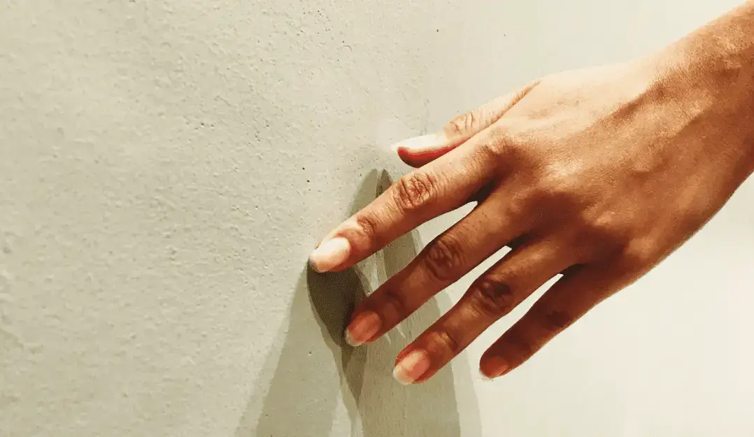 Close-up of a hand touching a smooth marble surface
