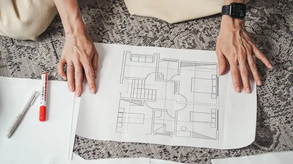 Designer's hands sketching a floor plan