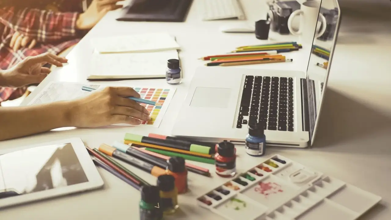 A collaborative work table with design sketches and laptops